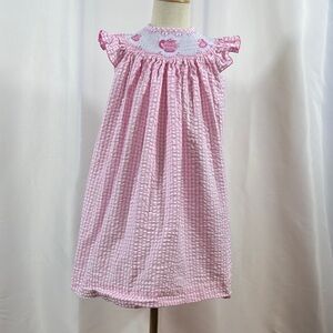 Adorable pink and white dress with ruffle sleeves and teapot/teacups smocking.